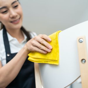 Asian cleaning service woman worker cleaning in living room at home.